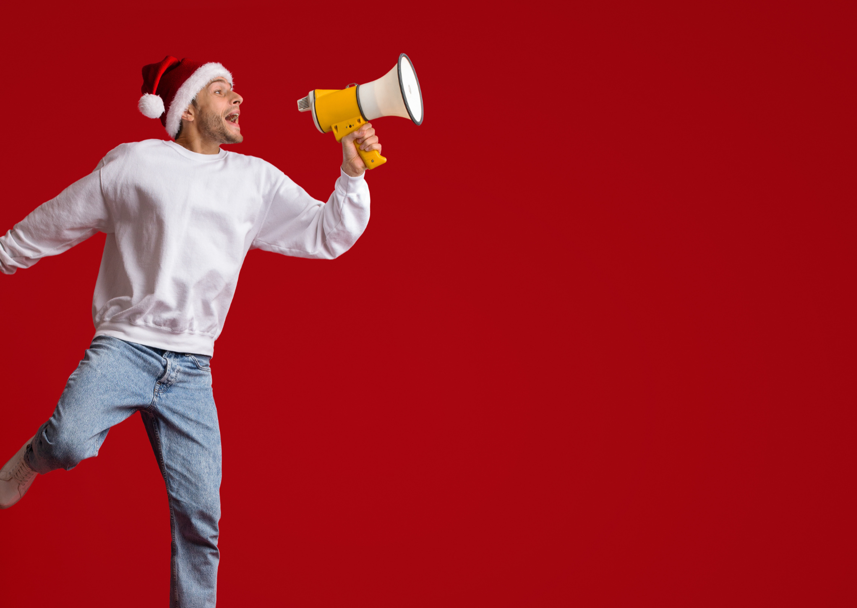 Mann mit Megaphon und Weihnachtsmütze spricht die DMC Tipps für die Feiertage.